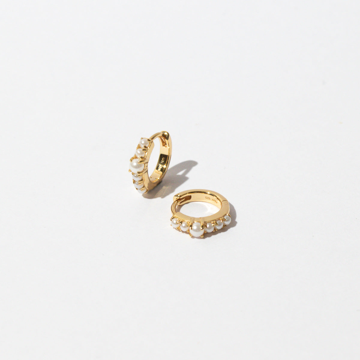 Radiant Pearl Huggies in Gold flat lay