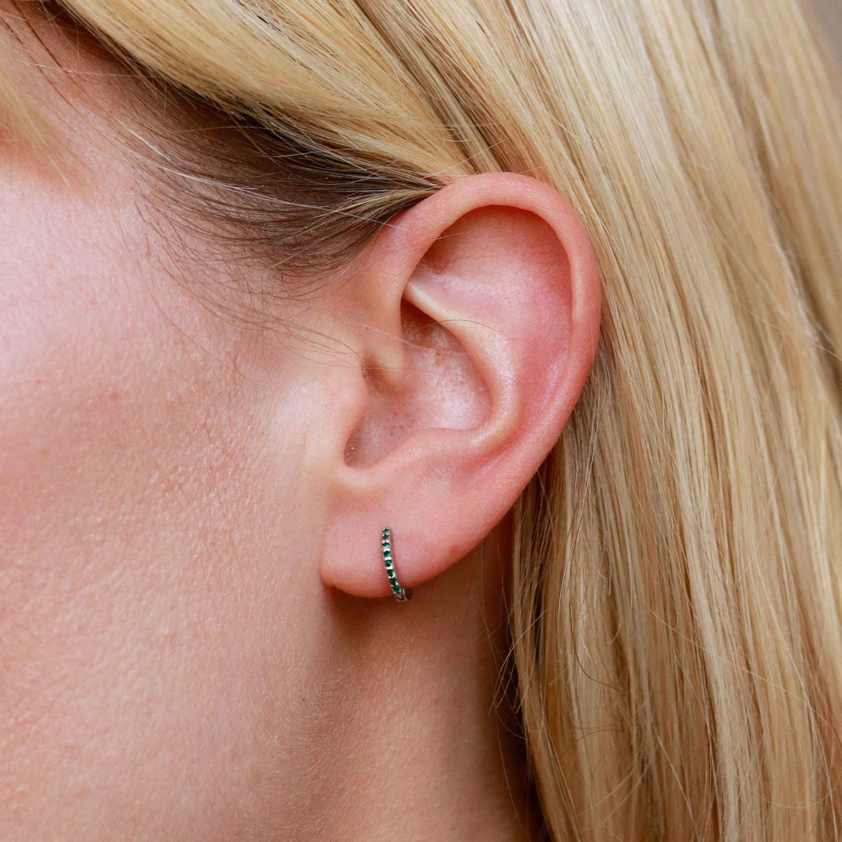 Emerald Green Jewelled Huggies in Silver worn in lobe piercing