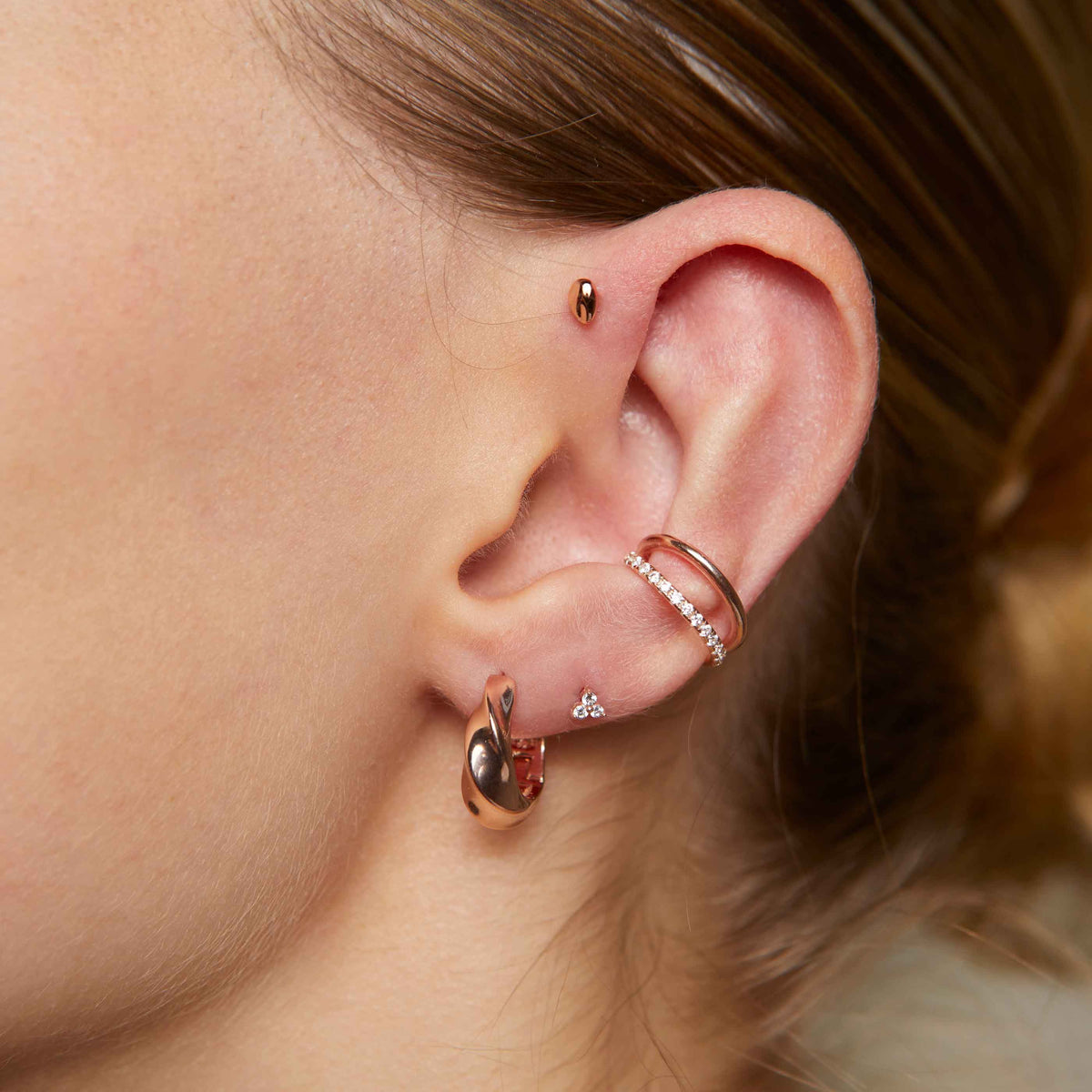 Triple Crystal Stud Earrings in Rose Gold worn with elemental hoops